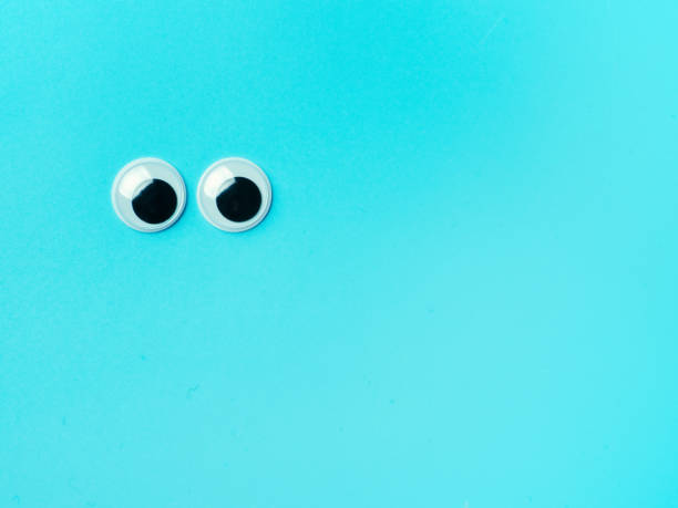 istock googly eyes on turquoise background, copy space 1251737648