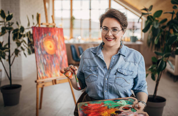 istock Cheerful female artist working in her studio 1251738886