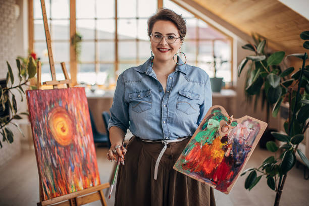 istock Creative artist with eyeglasses painting on canvas 1251739911