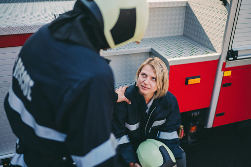 Woman firefighter after rescue operation talking with colleague