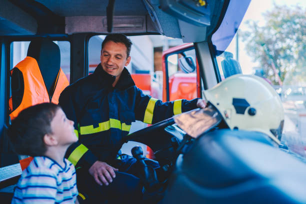 Kid dreaming to be a firefighter Little boy at the fire station chief of staff stock pictures, royalty-free photos & images