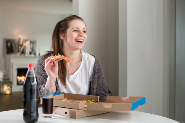 piękna młoda kobieta jedząca kawałek pysznej pizzy - eating food biting pizza zdjęcia i obrazy z banku zdjęć