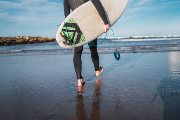 istock Surfer entering into the water with his surfboard. 1251759102