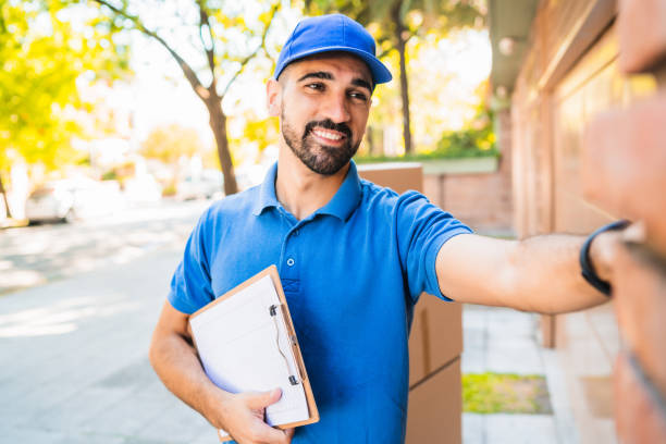 istock Delivery man carrying packages while making home delivery. 1251759641
