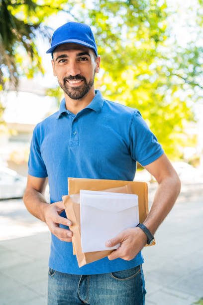 istock Postman carrying packages and letters. 1251759692