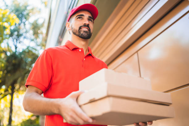 istock Delivery man carrying packages while making home delivery. 1251760206