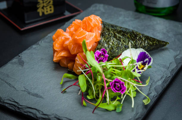 суши. тра�диционная японская кухня, премиальный лосось темаки оформлен в элегантной обстановке. - temaki food sushi salmon стоковые фото и изображения