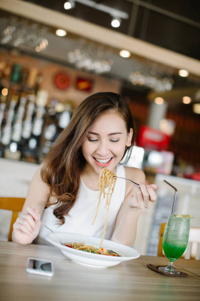 istock Young Asia woman eating spaghetti at restaurant 1251767533