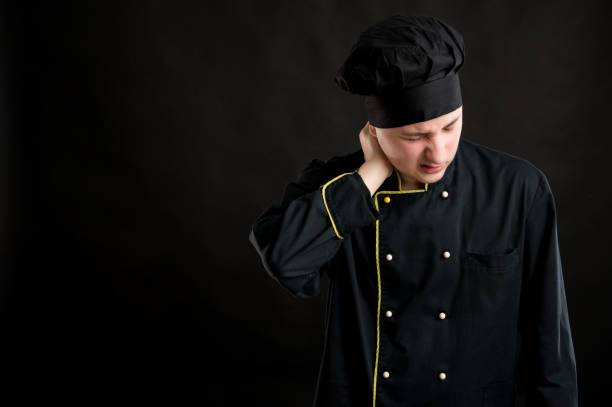 istock Young male dressed in a black chef suit has sore throat 1251769029