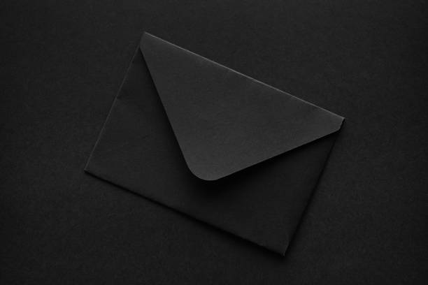 Black envelope on a black background. stock photo