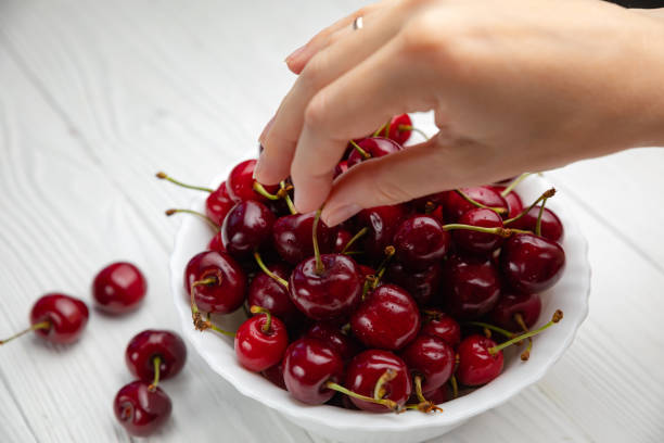 istock Isolated young woman holding a some cherries in her hands 1251775313