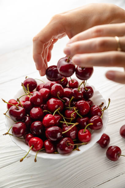 istock Isolated young woman holding a some cherries in her hands 1251775319