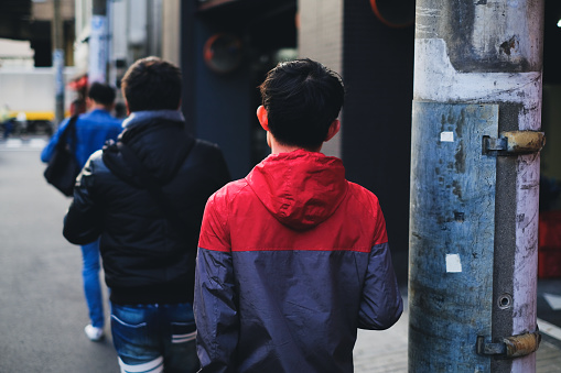 Young asian men walking on city street in Tokyo, Japan