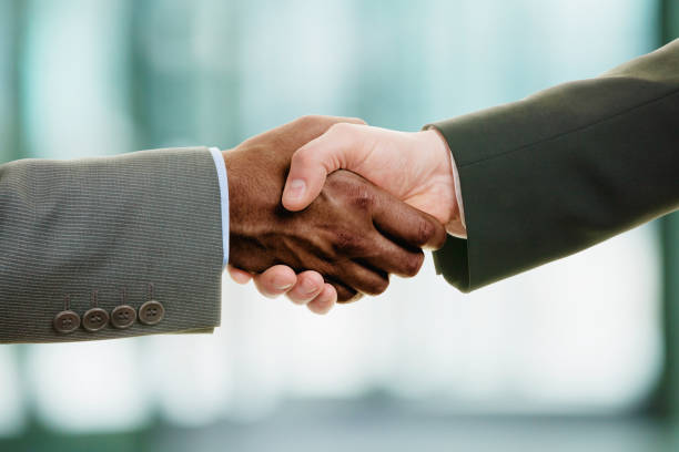 istock Interracial handshake on business background 1251801479