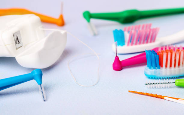 istock Different toothbrushes and dental floss on blue, close up. 1251811618