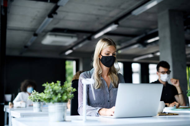 istock Young people with face masks back at work or school in office after lockdown. 1251819896