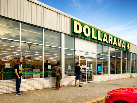 People in social distancing line waiting to shop at a Dollarama outlet. Some are wearing face masks to avoid contagion of the COVID-19 coronavirus.