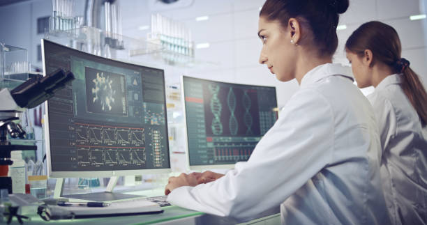 istock COVID-19 - laboratory female team working on coronavirus vaccine. Protective workwear 1251892299