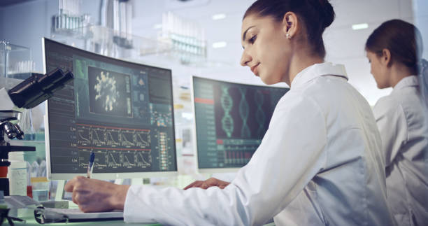 istock COVID-19 - laboratory female team working on coronavirus vaccine. Protective workwear 1251892302