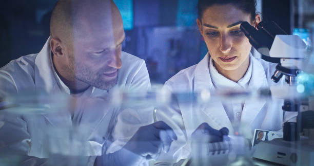 istock Working after hours in modern labolatory. Woman and man during research 1251894628