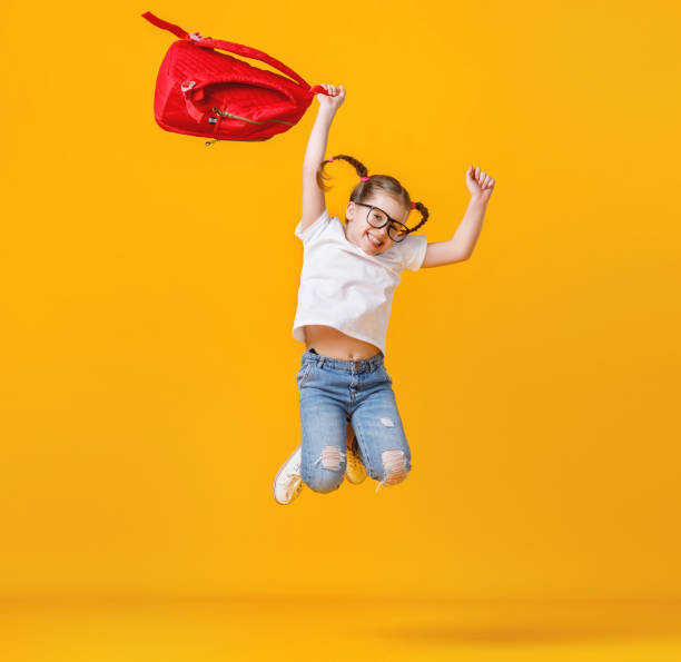 istock Happy schoolgirl with backpack jumping 1251899740
