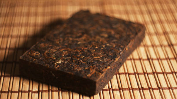 istock Brick of Chinese dark (pu-erh) tea on bamboo surface 1251908865