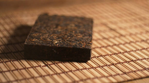 istock Brick of Chinese dark (pu-erh) tea on bamboo surface 1251909395