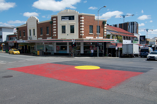 Brisbane, Queensland, Australia - 29th January 2020 : Big aboriginal flag painted on the pavement on intersection of Vulture St. and Boundary St. in West End Area in Brisbane