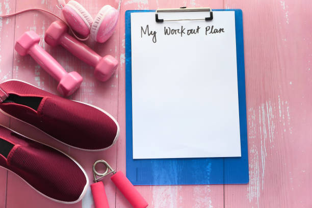 istock workout plan concept dumbbell, shoe and water bottle pink background 1251922499