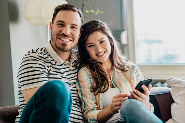 istock Couple using smart phone at home 1251934642