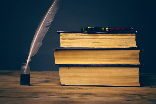 istock feather pen and books on the table 1251937034