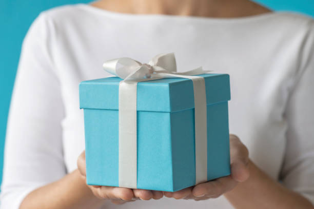 istock Woman Holding Gift Box 1251951476