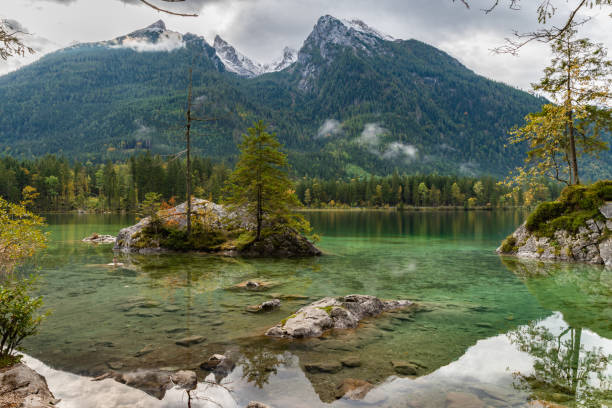 istock Stunning view Hintersee Lake Alps mountain beautiful reflection tree clear water, national park, Konigssee (Koenigssee) lake, Hochkalter Massif background Ramsau in Berchtesgaden, Bavaria, Germany 1251951509