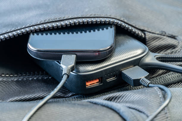 istock Smartphone charging with black power bank in backpack 1251957575