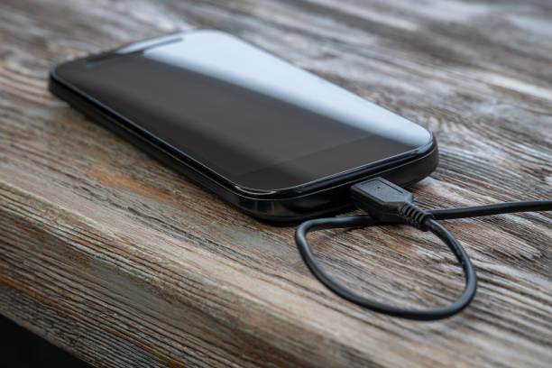 istock Smartphone charging with power bank on wooden table. 1251957584