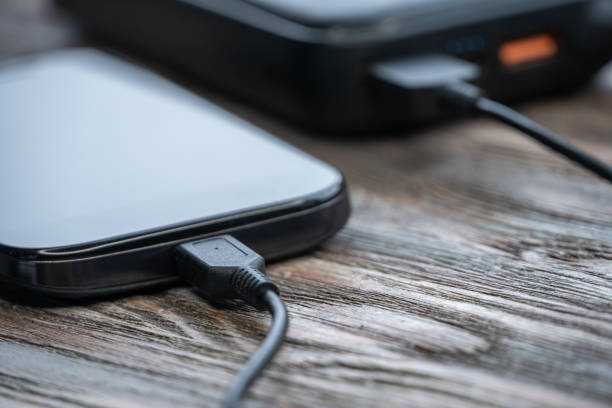 istock Smartphone charging with power bank on wood board 1251957596