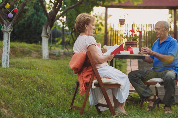 istock Senior woman reading a book while enjoying afternoon tea with her husband 1251957655