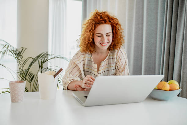 istock Young redhead woman is working from home 1251975739