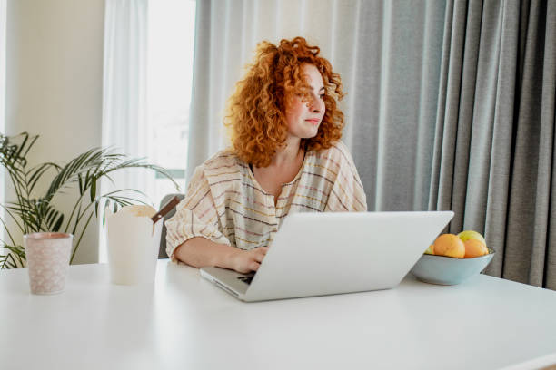 istock Young redhead woman is working from home 1251975741