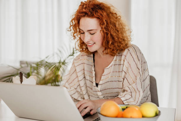 istock Young redhead woman is working from home 1251975870