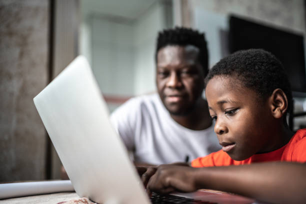 Father and son studying with laptop on a online class at home