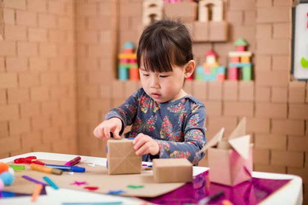 istock Preschooler making craft using cardboard blocks at home 1251998059