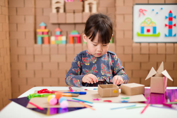 istock Preschooler making craft using cardboard blocks at home 1251998074