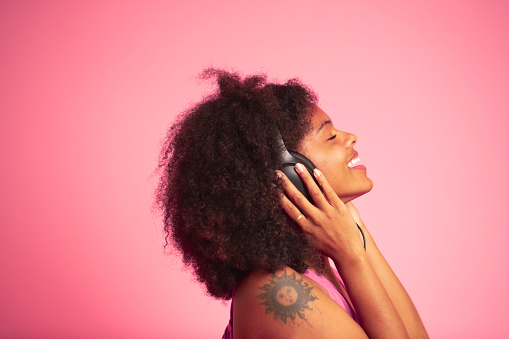An African American woman listening to music with her headphones.