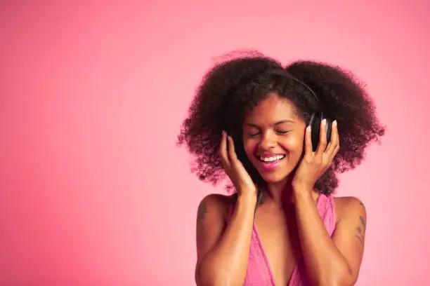 An African American woman listening to music with her headphones.