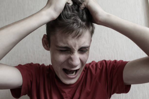 nastolatek facet w rozpaczy trzyma głowę i krzyczy - addiction family despair distraught zdjęcia i obrazy z banku zdjęć