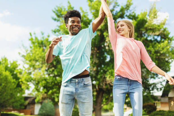 istock Multi Ethnic Heterosexual Generation Z Couple Holding Hands and Jumping and Laughing 1252012535
