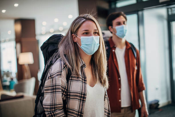 istock Young couple with protective face masks entering the hotel lobby 1252016003