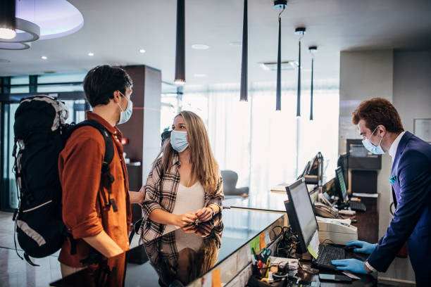 istock Young couple wearing protective face mask while doing check-in at the hotel reception 1252016041