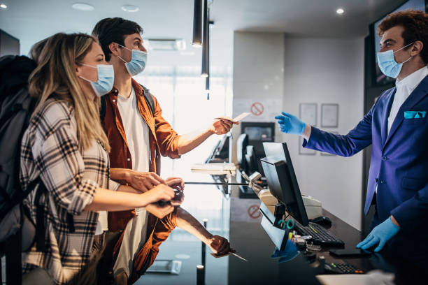 istock One young couple wearing protective face mask while doing check-in at the hotel reception 1252020045